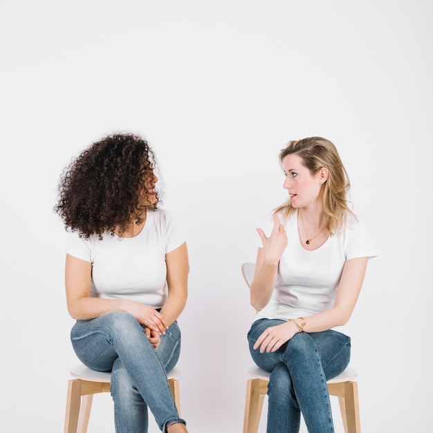 Les femmes sur les chaises parlent