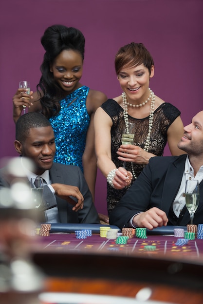 Photo femmes avec champagne debout à la table de roulette