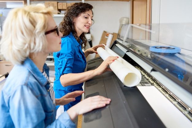 Femmes changeant de papier dans une presse à imprimer