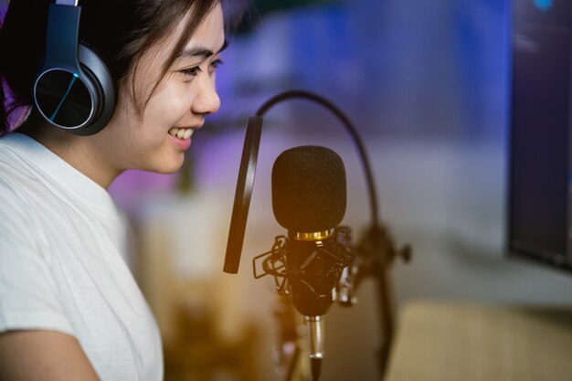 Femmes chanteuses chantant avec un casque enregistrant une nouvelle chanson dans le studio d'enregistrement à domicile