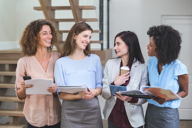 Femmes collègues debout avec fichier et tablette numérique