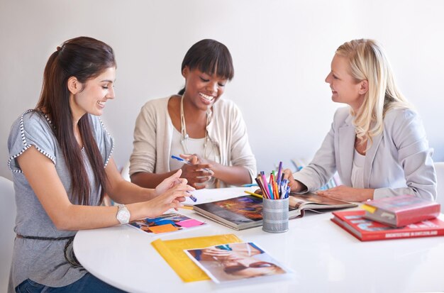 Femmes de conception créative et réunion de marketing au bureau pour la planification de la publicité et la collaboration en équipe Stratégie de diversité et jeunes dans un sourire heureux et une conversation de groupe