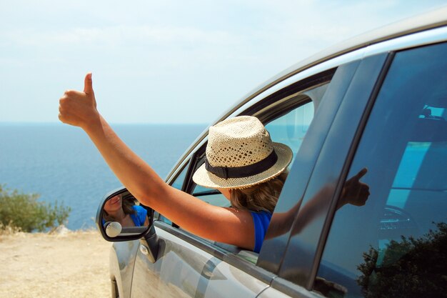 Femmes de conducteur en voiture en mer en été