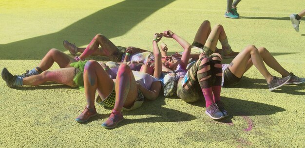 Photo des femmes couvertes de peinture en poudre allongées sur le champ.