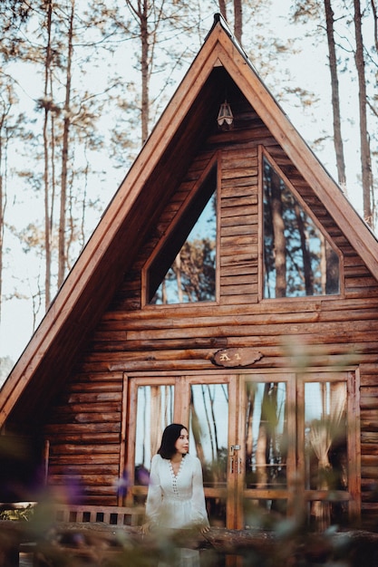 Photo des femmes dans des forêts de pins et des maisons de bois brunes