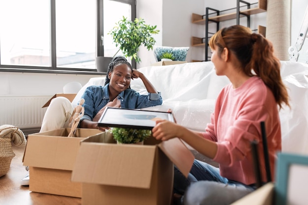 Les femmes déballent des boîtes et déménagent dans une nouvelle maison.