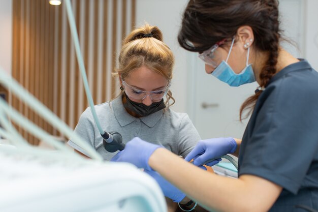 Les femmes dentistes traitent un patient