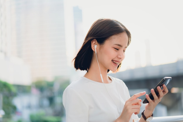 Les femmes écoutent de la musique avec un casque blanc.