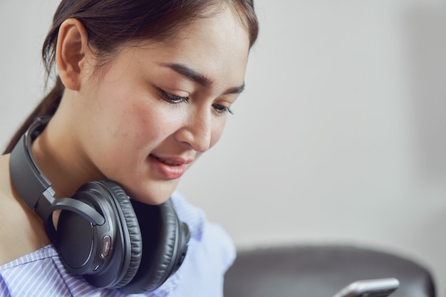 Les femmes écoutent de la musique avec un casque noir. De bonne humeur et confortable