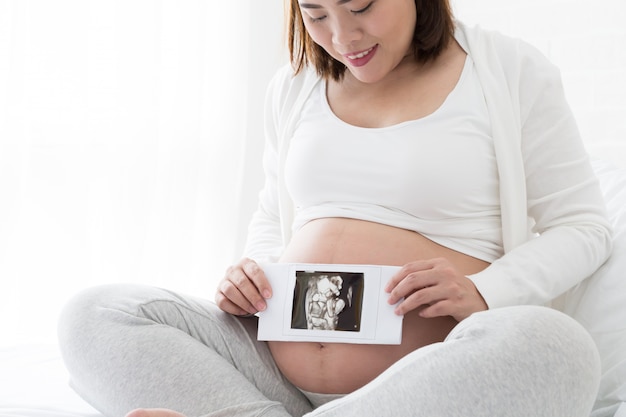 Femmes enceintes détenant des images échographiques en quatre dimensions