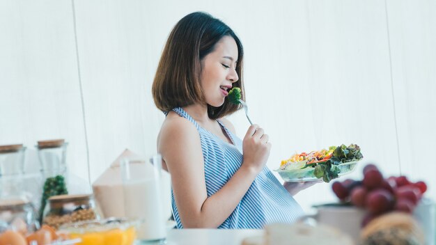 Les femmes enceintes mangent des salades de légumes délicieux et heureux.