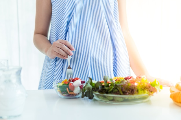 Femmes enceintes Mettez une robe bleue. Avoir du lait et de la salade sur la table.