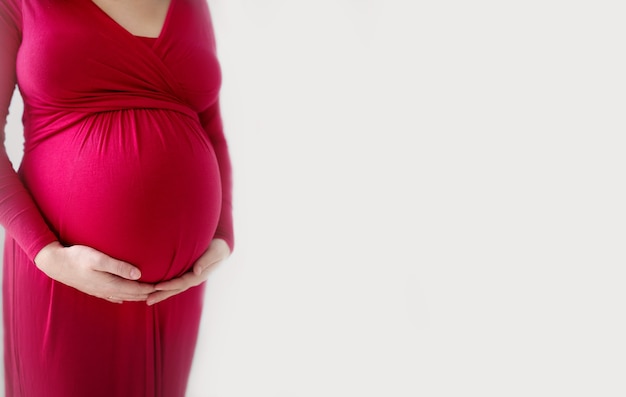 Les femmes enceintes tient ses mains sur son ventre de femme enceinte