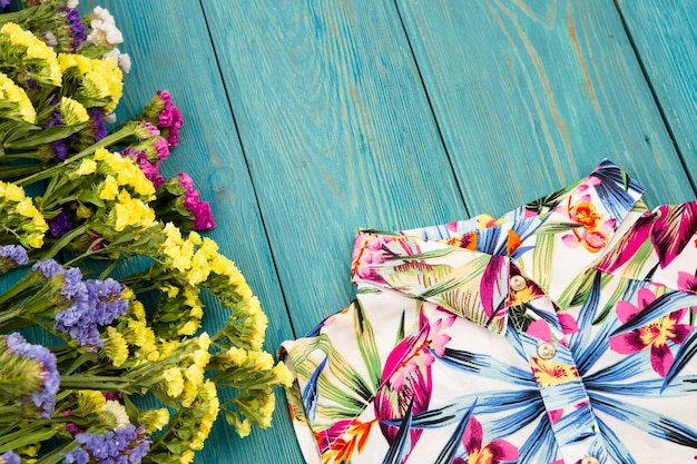 Femmes d'été sertie de robe et fleurs colorées sur bois bleu