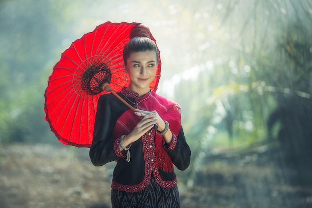 Femmes étrangères portant un parapluie rouge et un torchon rouge