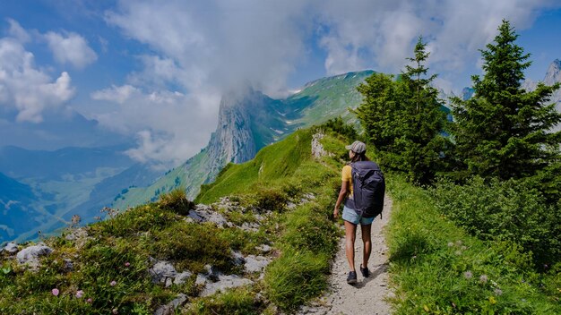 femmes faisant de la randonnée dans les Alpes suisses pendant les vacances d'été avec un sac à dos et des bottes de randonnée