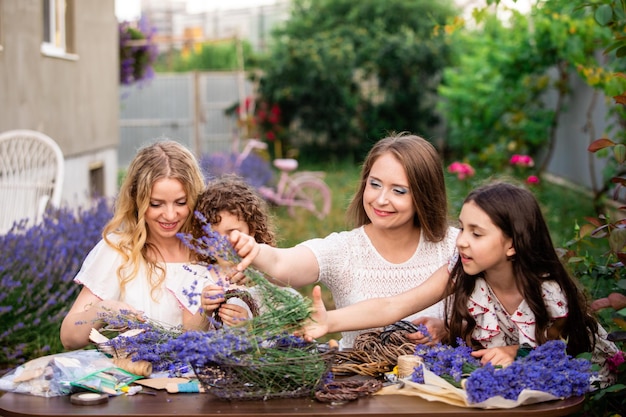 Femmes avec des filles faisant des bouquets de lavande à l'extérieur