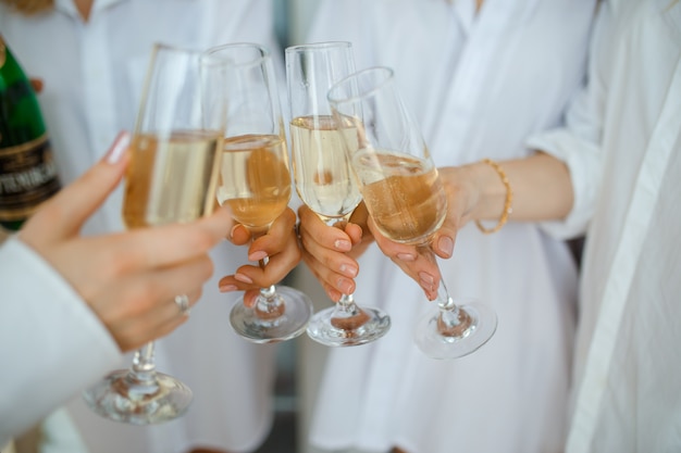 Femmes gaies tinter des verres de champagne à la fête