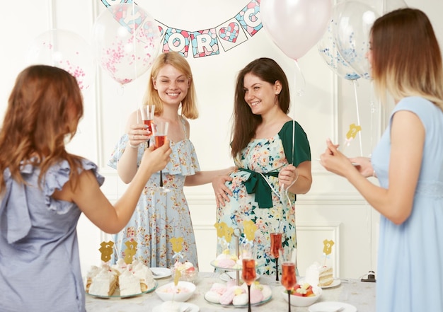 Des femmes heureuses célébrant ensemble pendant le genre révèlent la fête sur fond de ballons