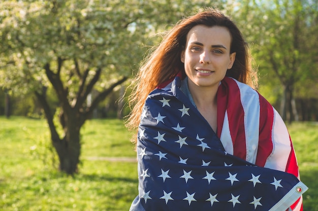 Les femmes heureuses avec le drapeau américain USA célèbrent le 4 juillet