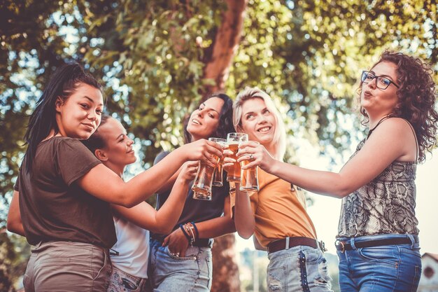 Photo des femmes heureuses font un toast de célébration sur terre