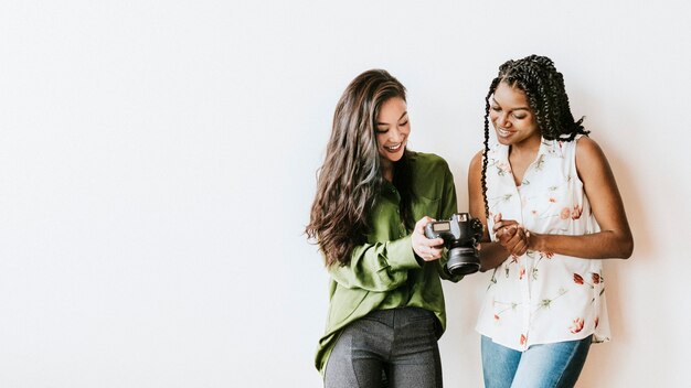 Femmes heureuses avec un modèle social parlant d'appareil photo numérique