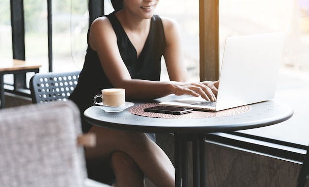 Femmes heureuses utilisant un ordinateur portable dans un café