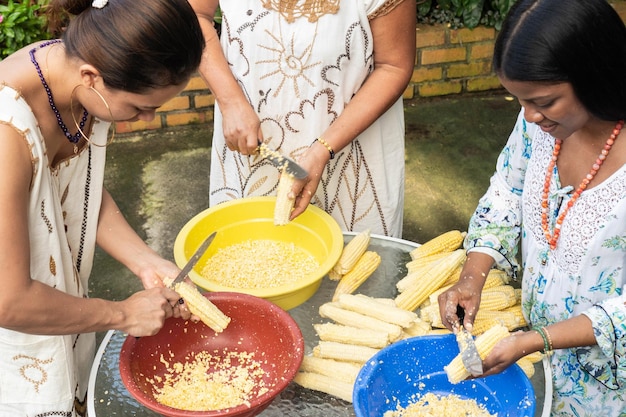 Femmes hispaniques Éplucher les épis de maïs