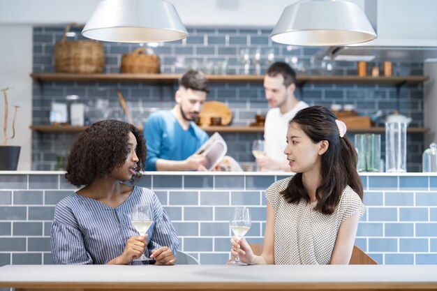 Femmes et hommes discutant à la table à manger