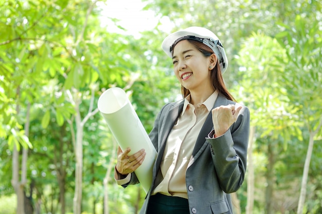 Les femmes ingénieurs en environnement portent un chapeau en papier pour étudier la faisabilité de la construction.