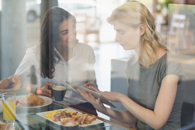 Femmes interagissant entre elles lors de l'utilisation d'une tablette numérique