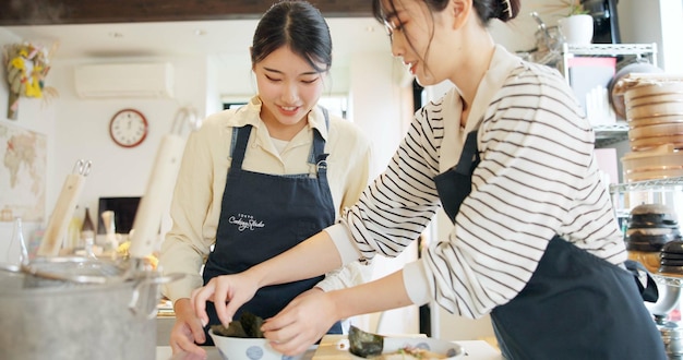 Les femmes japonaises et les chefs cuisiniers dans la cuisine avec la préparation de la nourriture La cuisine japonaise et le repas sain dans le restaurant La cuisine des gens et le déjeuner traditionnel avec le bonheur ou le bol pour le dîner et la culture
