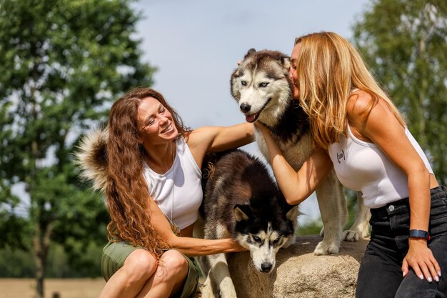 Des femmes joyeuses avec un chien à l'extérieur