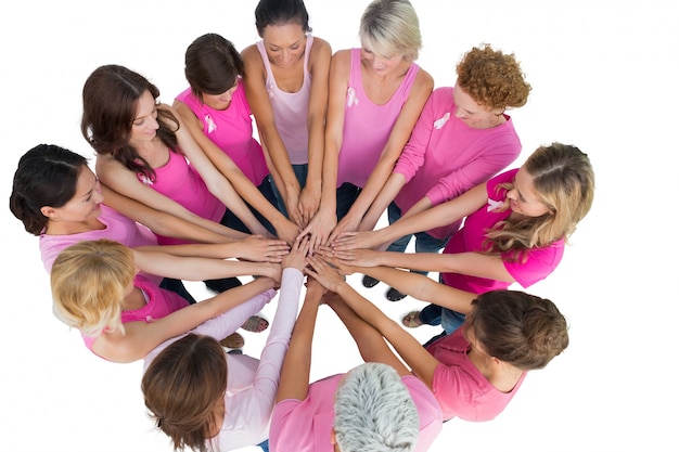 Femmes joyeuses jointes dans un cercle vêtu de rose pour le cancer du sein