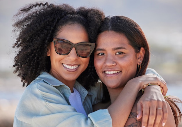 Femmes lgbtq et portrait de plage heureux pour l'amour câlin et les soins pendant les vacances d'été et la fierté arc-en-ciel Gay lesbienne et jeune couple d'amis se détendre en mer océan ou bonheur en plein air dans la nature