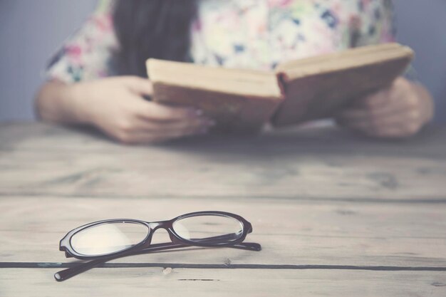 Les femmes lisent un livre sur une table en bois