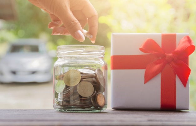 Femmes main empilant des pièces de monnaie avec fond de voiture