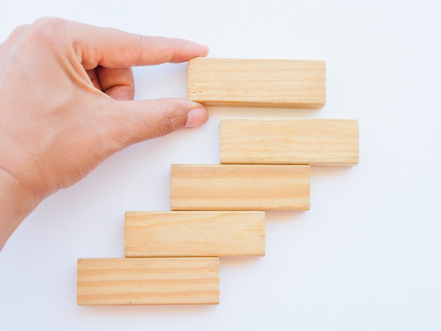 Des femmes à la main mettent des blocs de bois en forme d&#39;escalier