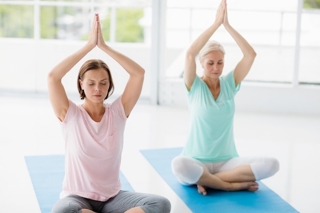 Femmes avec les mains jointes faisant du yoga