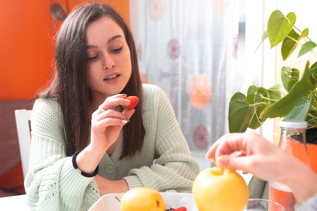 Femmes mangeant des fruits au salon