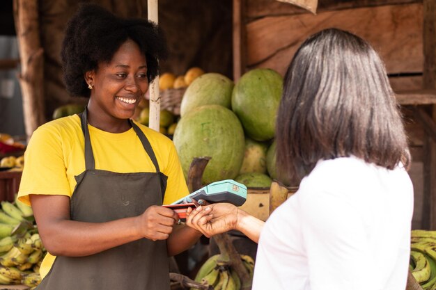 Femmes sur un marché, payant par carte de crédit