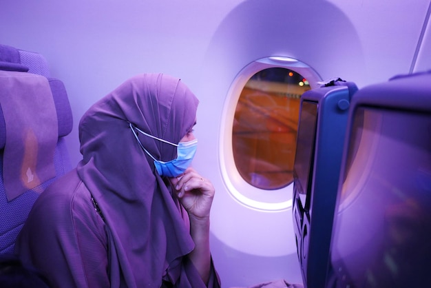 Femmes avec un masque facial assis sur des sièges d'avion dans la cabine