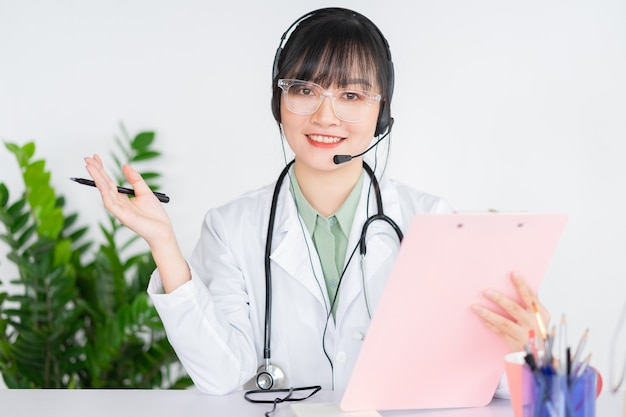 Les femmes médecins asiatiques examinent les patients à distance, les médecins peuvent désormais utiliser un logiciel d'appel vidéo sur des ordinateurs pour rechercher des clients en ligne.