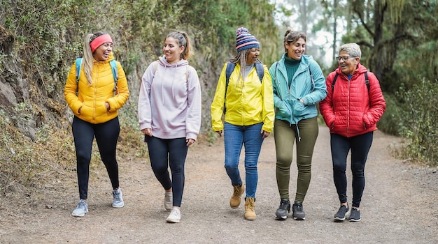 Photo femmes multiraciales s'amusant pendant une journée de trekking dans le bois - focus sur les visages