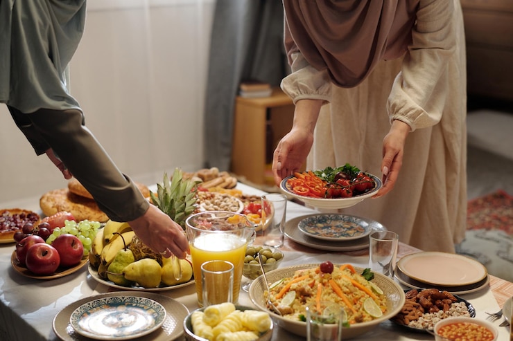 Photo des femmes musulmanes méconnaissables préparent une table de fête