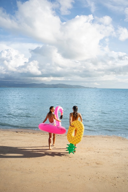 Femmes pleines avec des flotteurs à la plage