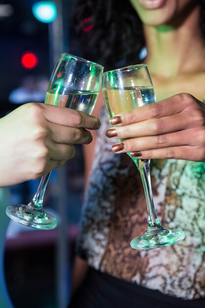 Femmes portant leurs verres de champagne au bar