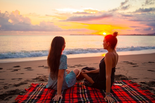 Femmes portant sur la plage, profitant des vacances d'été en regardant la mer