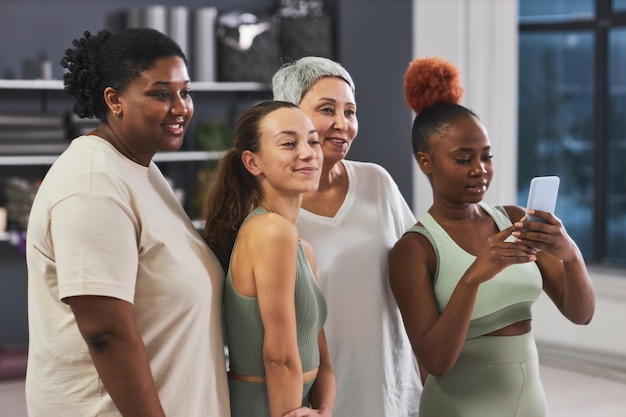 Photo femmes posant devant la caméra d'un smartphone