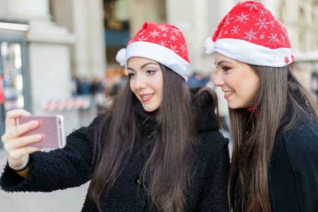 Femmes prenant un selfie lors de leurs achats à Milan